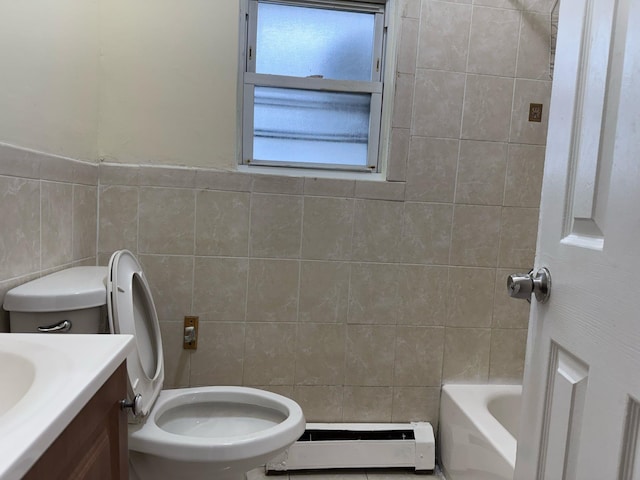 full bathroom with tile walls, toilet, vanity, a baseboard heating unit, and a bath