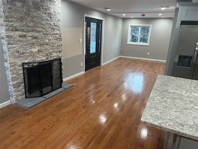 unfurnished living room with a fireplace and hardwood / wood-style floors