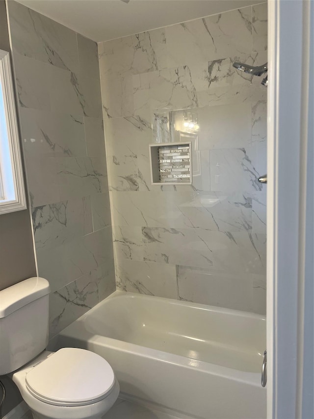 bathroom featuring toilet and tiled shower / bath combo