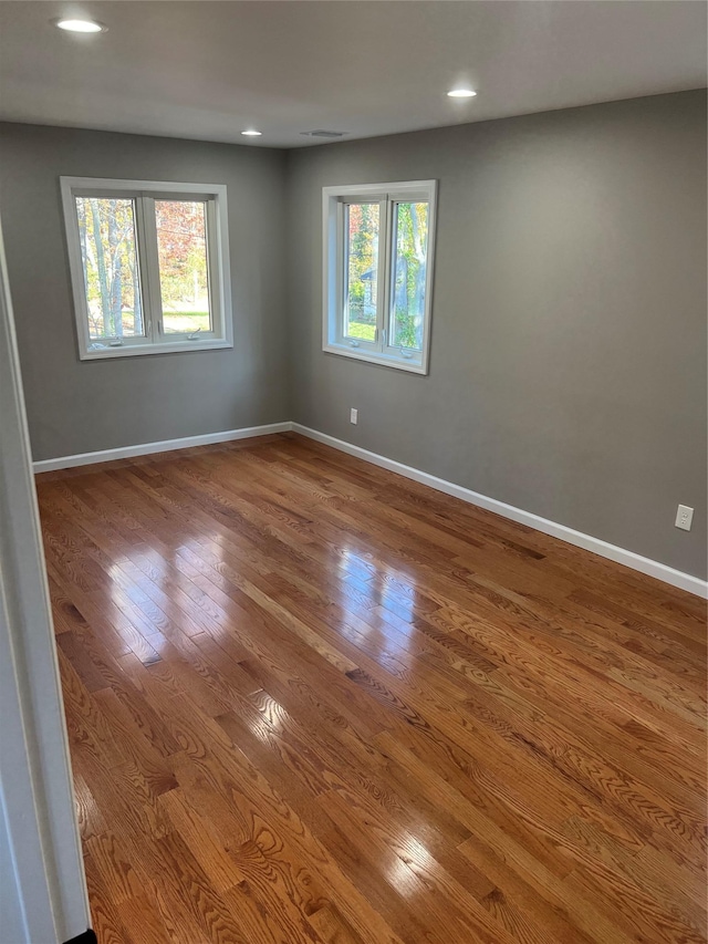 spare room featuring hardwood / wood-style floors and a healthy amount of sunlight