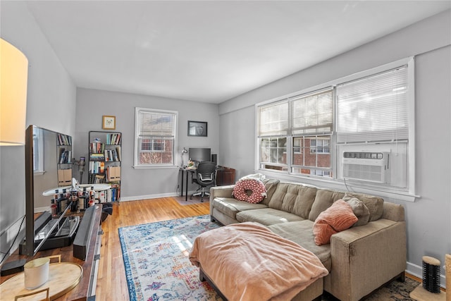 living room featuring baseboards, cooling unit, and wood finished floors