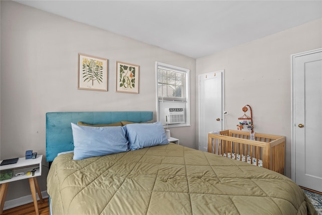 bedroom featuring cooling unit and wood finished floors