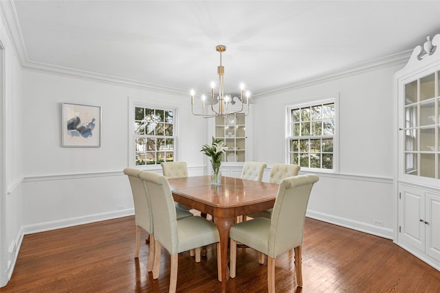 dining space with baseboards, crown molding, an inviting chandelier, and wood finished floors