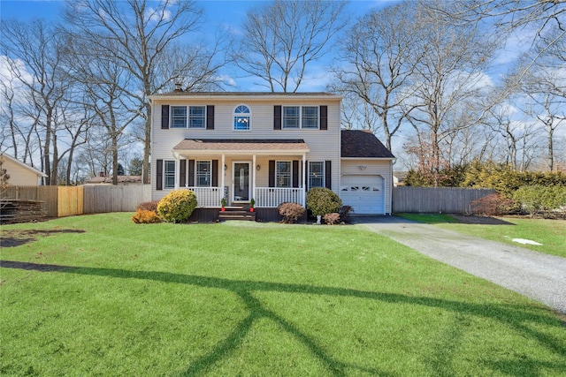 colonial home with driveway, a porch, a front lawn, and fence