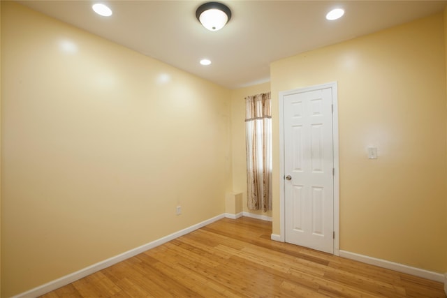 unfurnished room with light wood finished floors, recessed lighting, and baseboards