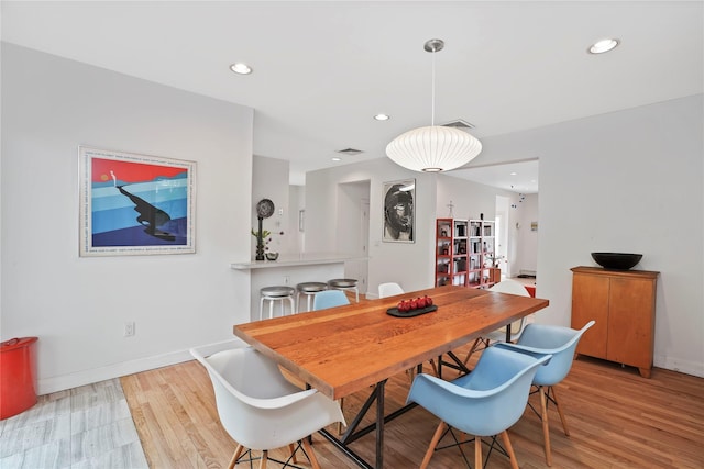 dining room featuring light wood-style flooring, recessed lighting, and baseboards