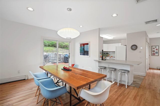 dining area with baseboard heating, light wood-style flooring, recessed lighting, and baseboards