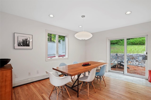 dining space with a baseboard heating unit, plenty of natural light, light wood finished floors, and recessed lighting
