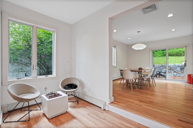 sitting room featuring baseboard heating, healthy amount of natural light, light wood-style floors, and recessed lighting