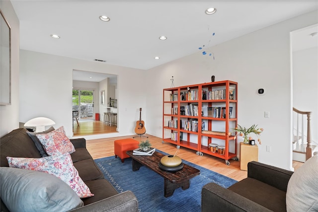 living area featuring wood finished floors, recessed lighting, and stairs