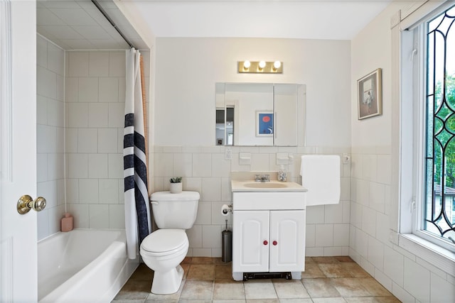 bathroom featuring tile walls, toilet, vanity, tile patterned flooring, and shower / tub combo with curtain