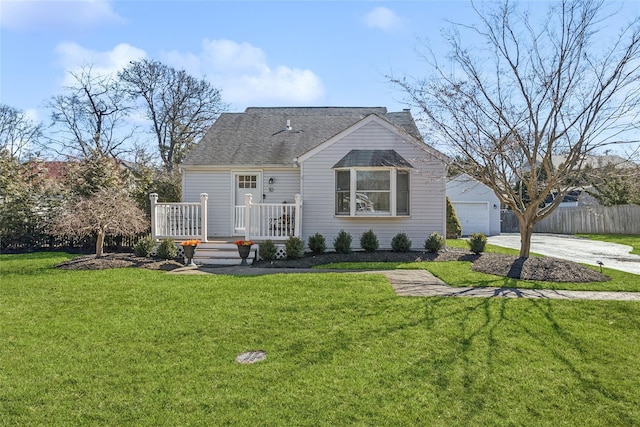 view of front of house featuring a deck, a shingled roof, fence, driveway, and a front yard