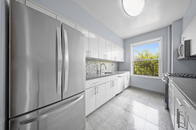 45-08 40th St Unit F32, Sunnyside, NY 11104 - kitchen with backsplash, granite finish floor, a sink, white cabinets, and stainless steel appliances