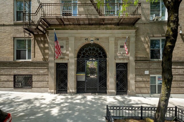 45-08 40th St Unit F32, Sunnyside, NY 11104 - view of exterior entry featuring fence and a balcony