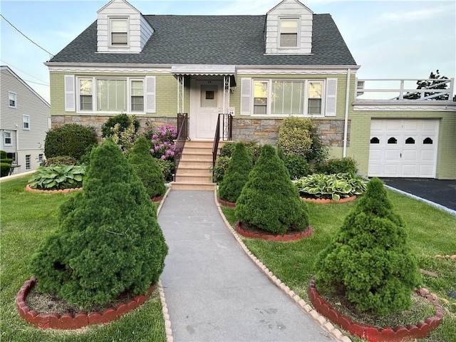 new england style home featuring a front lawn and a garage