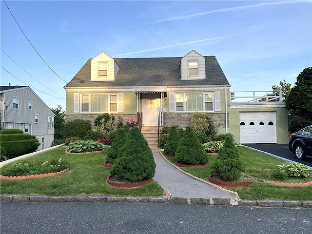 new england style home featuring a front yard and a garage