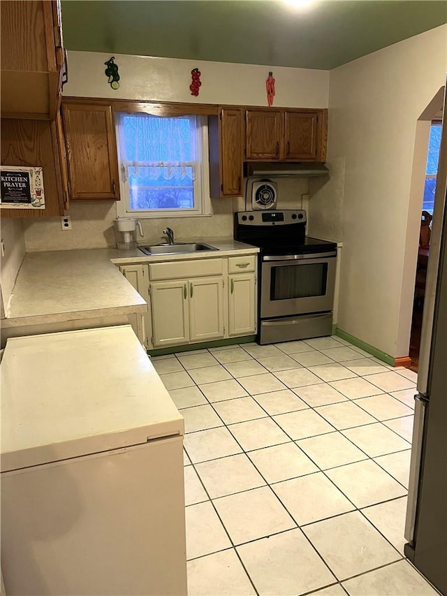 kitchen with sink, stainless steel electric range, and light tile patterned floors