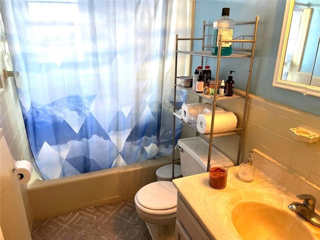 full bathroom with tile walls, vanity, toilet, and shower / bath combo