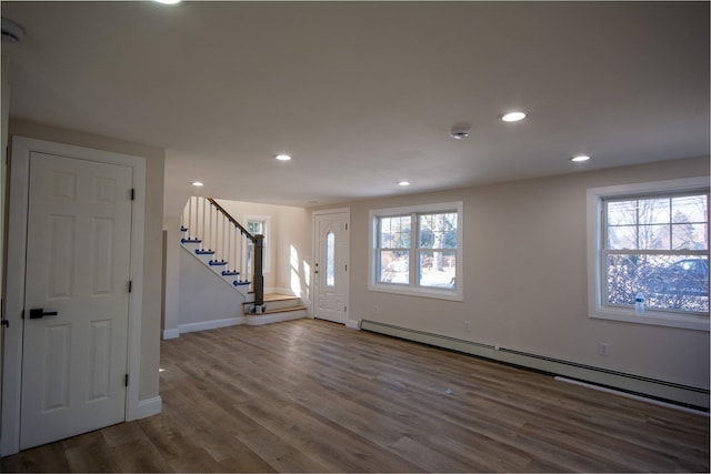 entrance foyer with a baseboard radiator, stairway, recessed lighting, and wood finished floors