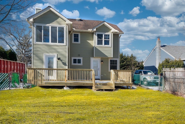 rear view of house with a yard, a chimney, a wooden deck, and fence