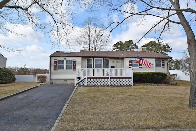 view of front of property with a chimney, aphalt driveway, crawl space, fence, and a front lawn