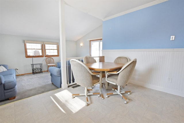 dining room featuring vaulted ceiling and wainscoting