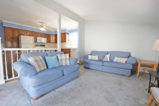 living room with ornamental molding, light colored carpet, and ceiling fan