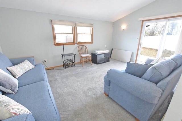 carpeted living area featuring lofted ceiling and baseboards