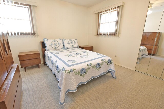 carpeted bedroom with a closet and baseboards