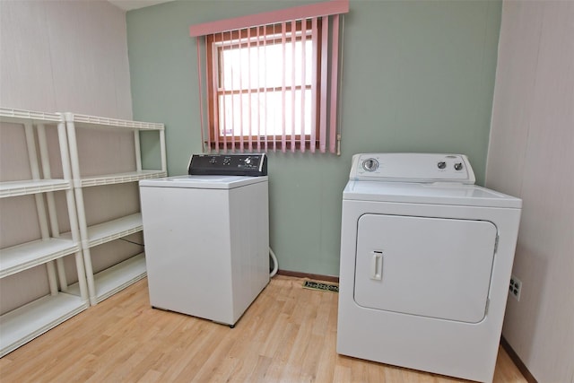 laundry area with laundry area, baseboards, wood finished floors, and independent washer and dryer