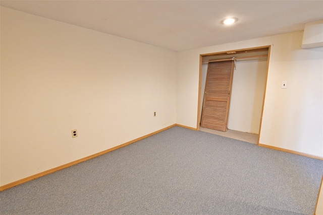 unfurnished bedroom with light carpet, a closet, and baseboards