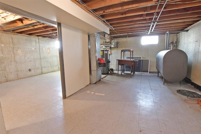 basement with water heater, tile patterned floors, electric panel, and heating fuel