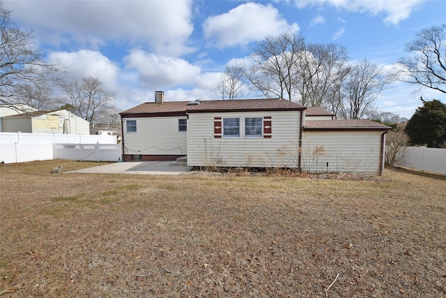 back of property with a yard, a patio area, and a fenced backyard