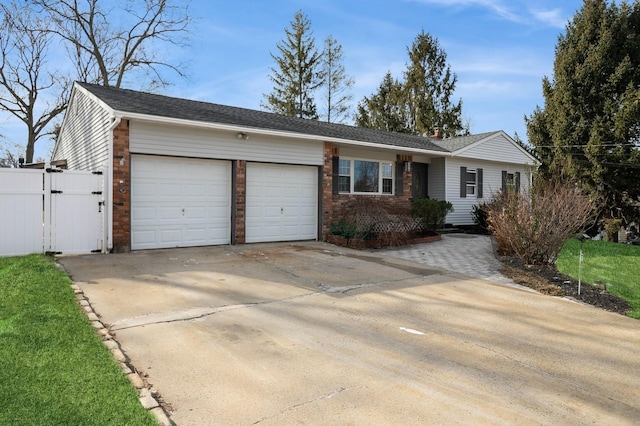 ranch-style home with an attached garage, concrete driveway, and brick siding