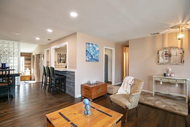 living area with baseboards, dark wood-type flooring, visible vents, and recessed lighting