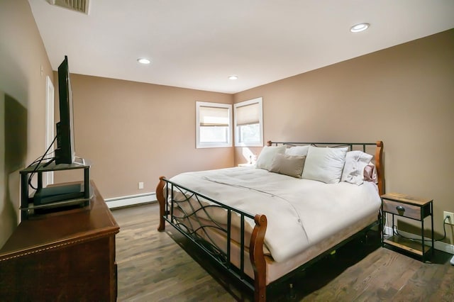 bedroom featuring baseboards, baseboard heating, dark wood-type flooring, and recessed lighting