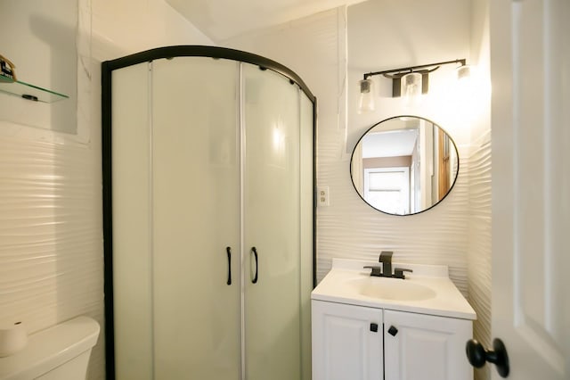 bathroom featuring toilet, a shower stall, and vanity