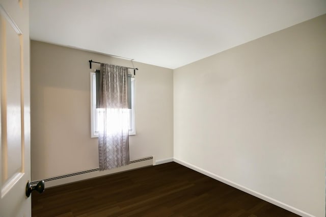 empty room featuring dark wood-type flooring, baseboards, and baseboard heating