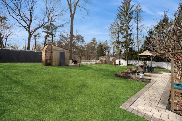 view of yard with an outbuilding, a storage unit, and a fenced backyard