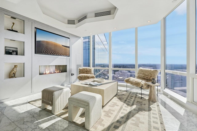 interior space featuring a lit fireplace and a raised ceiling