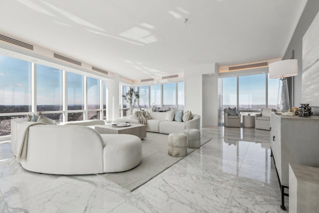 living area featuring marble finish floor, visible vents, and plenty of natural light