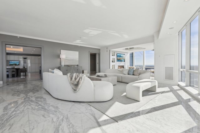 living room featuring a healthy amount of sunlight, marble finish floor, and ornamental molding