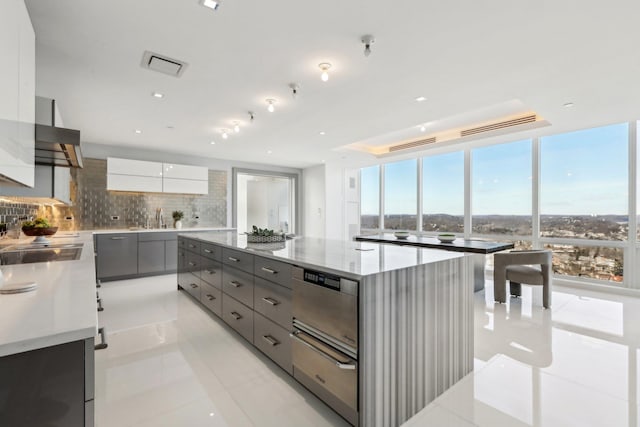 kitchen featuring modern cabinets, decorative backsplash, gray cabinets, and a warming drawer