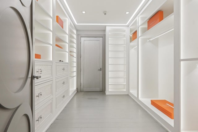 walk in closet with light wood-style floors