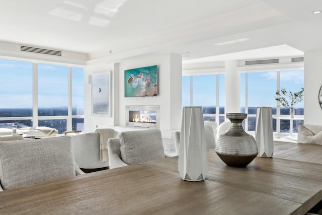 dining room featuring wood finished floors, a multi sided fireplace, and visible vents