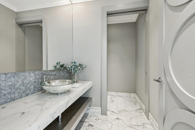 bathroom with marble finish floor, crown molding, vanity, and baseboards