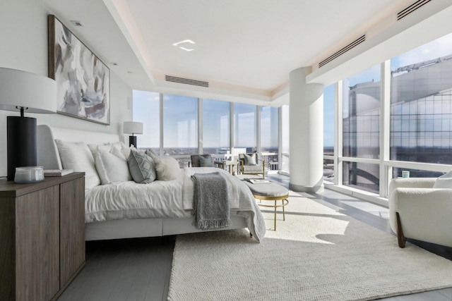 bedroom featuring expansive windows, visible vents, and wood finished floors