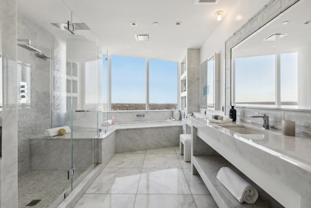 full bathroom featuring a stall shower, visible vents, a garden tub, and vanity