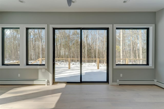 doorway to outside featuring light hardwood / wood-style floors and a baseboard radiator