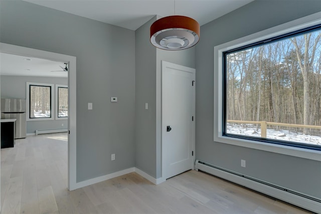 foyer with baseboard heating and light hardwood / wood-style floors